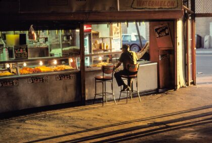 The late afternoon sun pours in on a man sitting at a lunch counter near Coney Island in 1980.